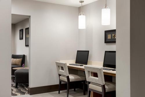 an office with a desk with two computers and chairs at Staybridge Suites Fort Wayne by IHG in Fort Wayne