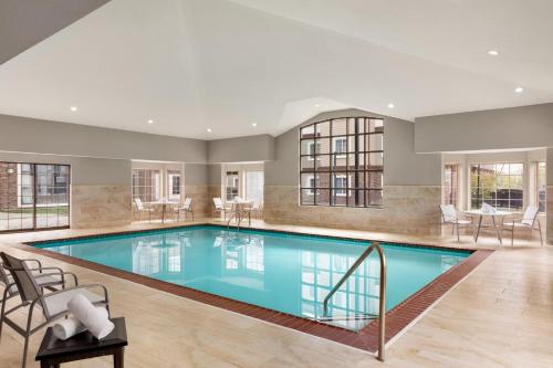 una gran piscina con sillas y mesas en una casa en Staybridge Suites Fort Wayne, an IHG Hotel en Fort Wayne