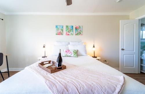 a white bed with a bottle of wine on it at Renovated Studio - Steps to Beach, POOL, & Cabana! in Panama City Beach