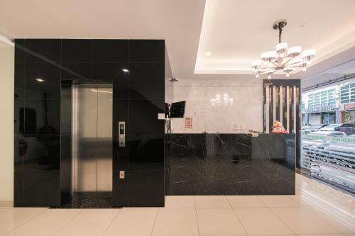 un ascenseur dans un immeuble avec un mur noir dans l'établissement STAR MOON HOTEL, à Bintulu
