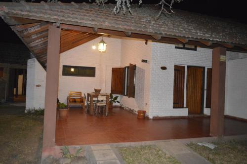un patio de una casa con mesa y sillas en Cabañas Tres Ríos Vacacional en Villa Cura Brochero