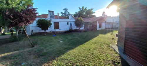 un patio trasero de una casa con un patio con césped en Cabañas Tres Ríos Vacacional en Villa Cura Brochero