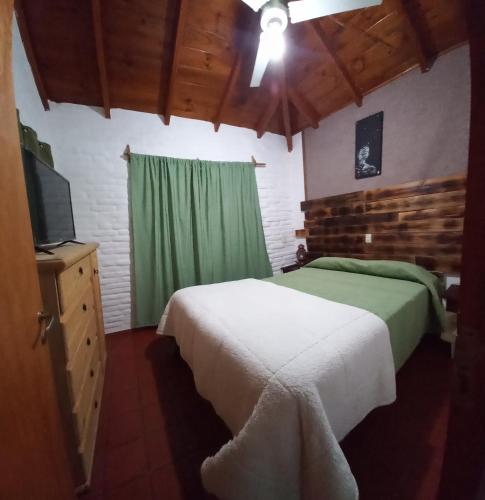 a bedroom with two beds and a television in a room at Cabañas Tres Ríos Vacacional in Villa Cura Brochero