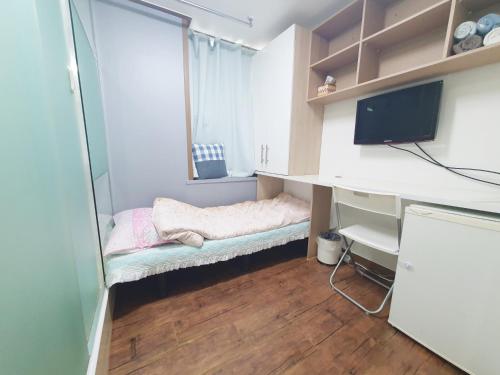 um pequeno quarto com uma cama e uma secretária em Apgujeong Home em Seul