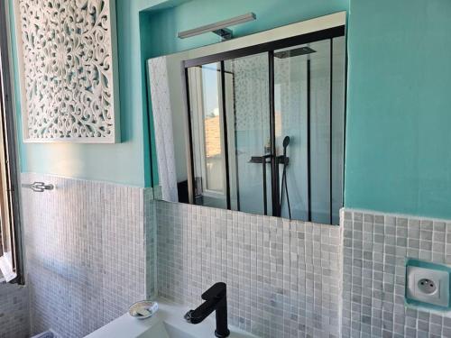 uma casa de banho com um lavatório e um espelho em Appt 35 m² dans maison de charme em Mèze