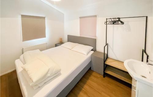 biała sypialnia z łóżkiem i umywalką w obiekcie Gorgeous stacaravan In Putten With Wifi w mieście Putten