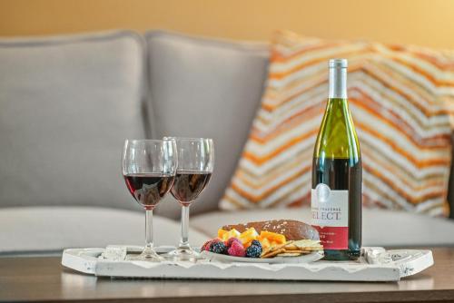 a tray with two wine glasses and a bottle of wine at LONG LAKE RETREAT- Hot tub, Pool table, Firepit in Traverse City