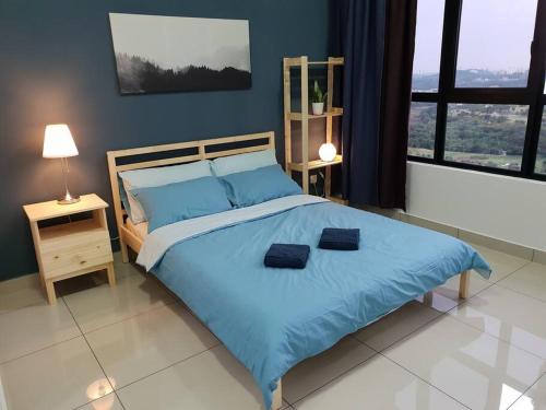 a bedroom with a large blue bed with blue pillows at Alpine Conezion Golf View Netflix at IOI City Mall in Putrajaya