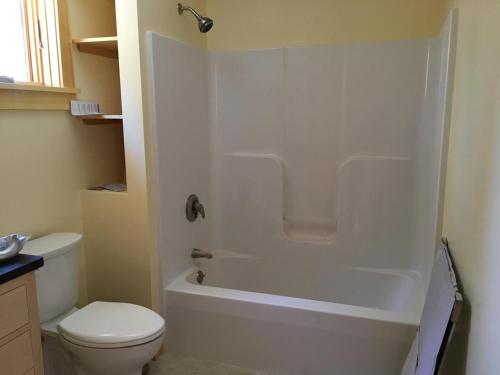 biała łazienka z toaletą i prysznicem w obiekcie Poseidon w mieście Deer Isle