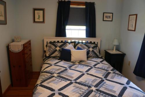 1 dormitorio con 1 cama con edredón azul y blanco en Point Field en Deer Isle