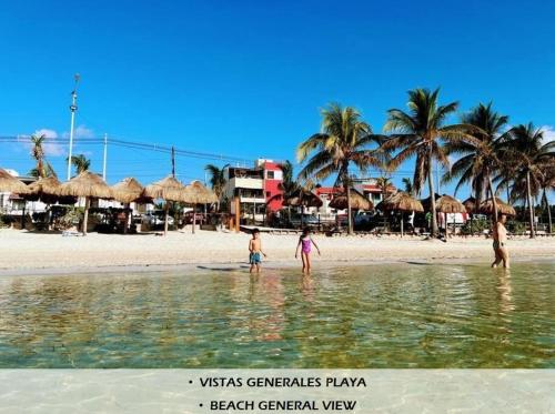 a group of people standing in the water on a beach at Apartamentos Magali in Cancún