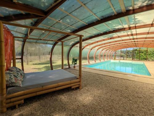 une pergola avec un lit et une piscine dans l'établissement Charmant gîte familial avec piscine chauffée, parc et animaux - 3 chambres, internet, équipements bébé - FR-1-653-233, à Chadurie