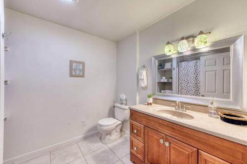 a bathroom with a toilet and a sink and a mirror at Charming Modern 3BR Fresno House in Fresno