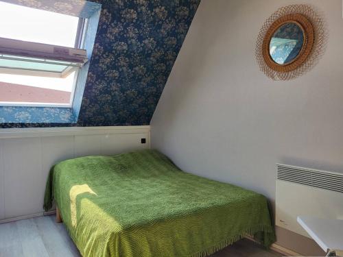 - une petite chambre avec un lit vert et une fenêtre dans l'établissement Duplex en front de mer avec balcon à Merville-Franceville-Plage - FR-1-465-99, à Merville-Franceville-Plage