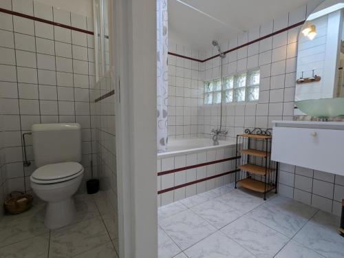 une salle de bain avec toilettes, baignoire et lavabo dans l'établissement Petit gîte romantique avec piscine couverte, jardin et animaux, proche de la nature à Chadurie - FR-1-653-234, à Chadurie