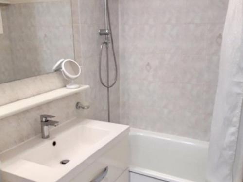 une salle de bain blanche avec une douche et un lavabo dans l'établissement Charmant T2 avec Piscine, Tennis, Wifi et Garage à Bormes-les-Mimosas - FR-1-610-92, à Bormes-les-Mimosas