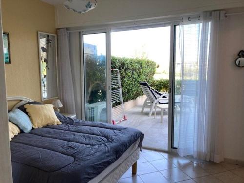 1 Schlafzimmer mit einem Bett und einem Balkon mit Aussicht in der Unterkunft Appartement Le Lavandou, 2 pièces, 4 personnes - FR-1-308-181 in Le Lavandou