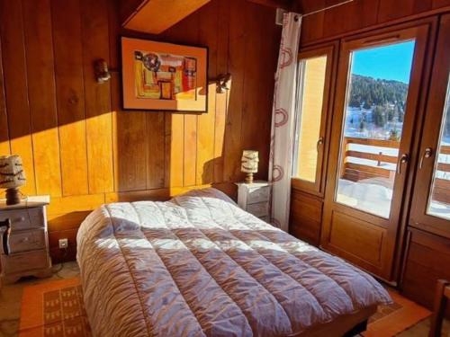 een slaapkamer met een bed in een kamer met een raam bij Appartement Chamrousse, 2 pièces, 6 personnes - FR-1-340-271 in Chamrousse