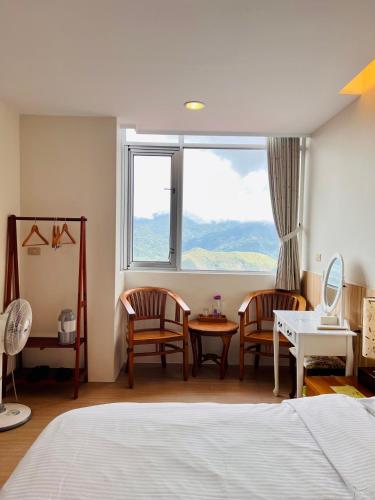 a bedroom with a bed and two chairs and a window at Yun pu cha jan in Fanlu