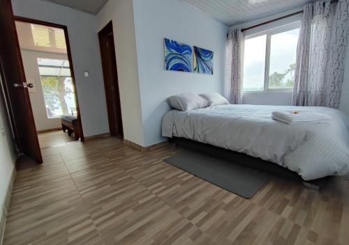 sypialnia z łóżkiem i dużym oknem w obiekcie Finca La Piedra w mieście Aquitania
