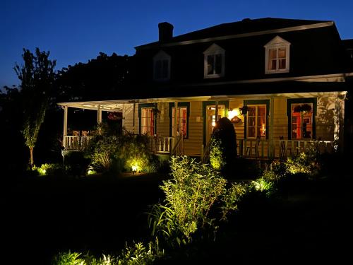 a house with lights in the yard at night at Auberge musicale Pour un Instant in La Malbaie