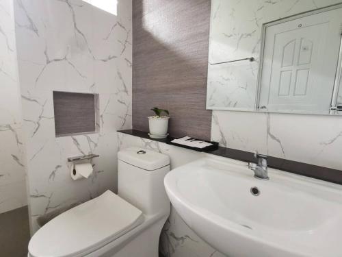 a bathroom with a toilet and a sink and a mirror at How Hide Space in Kanchanaburi