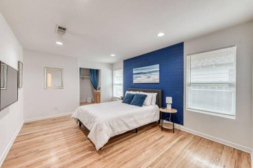 a bedroom with a bed and a blue accent wall at The Happy Hideaway 1BR Unit in Fresno