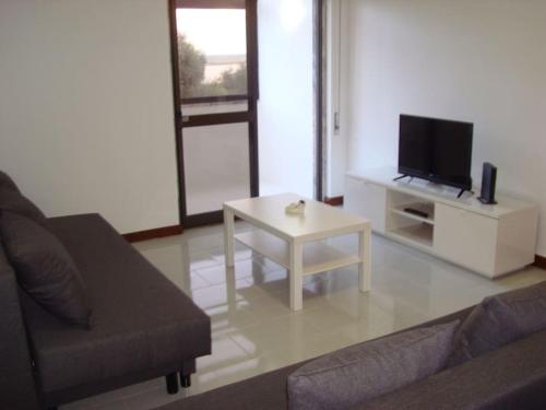 a living room with a couch and a tv and a table at 1Bed Tagus River View in Alhandra