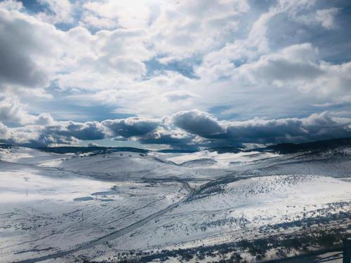 an aerial view of a snow covered field with clouds at Carinya Village Jindabyne in Jindabyne