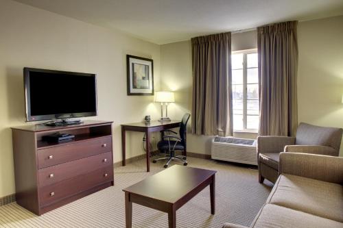 a hotel room with a living room with a television and a couch at Cobblestone Inn & Suites-Winterset in Winterset