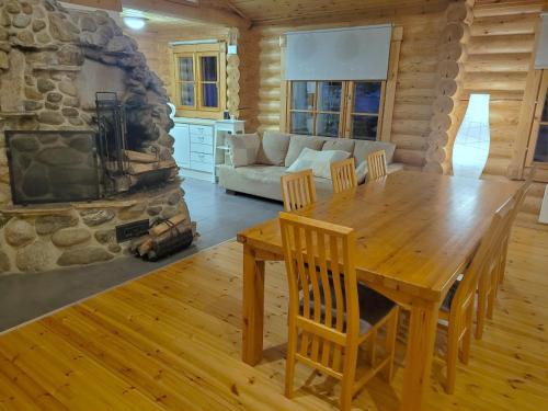 a dining room with a table and a fireplace at Karelian Country Cottages in Rastinniemi