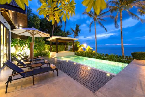 a villa with a swimming pool at night at The Sea Koh Samui Resort and Residences by Tolani - SHA Extra Plus in Koh Samui 