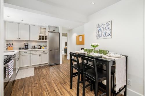 a kitchen with a black table and chairs in a kitchen at Gorgeous 4 Bedroom Garden Level Suite at Vancouver West & UBC in Vancouver