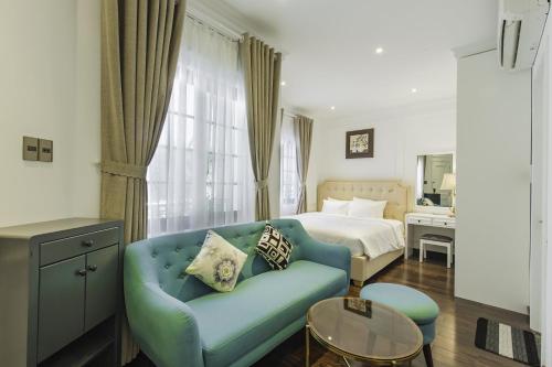 ein Wohnzimmer mit einer blauen Couch und einem Bett in der Unterkunft Grand Villa Residence Vũng Tàu in Vũng Tàu
