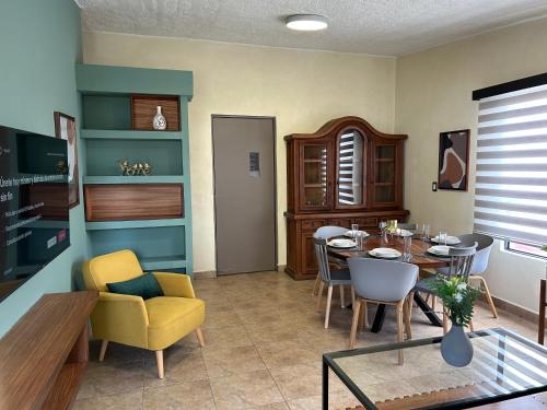 a living room with a table and a dining room at Xochimilco Apartment in Oaxaca City