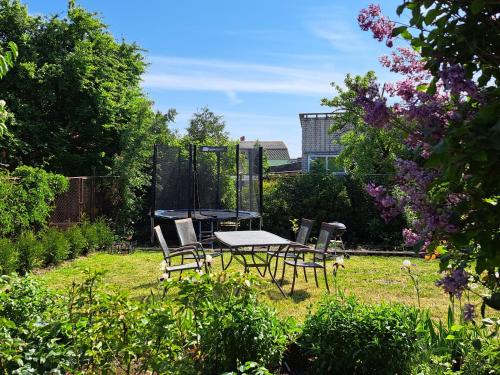 een picknicktafel en stoelen in de tuin bij Liepājas brīvdienu māja ar dārzu in Liepāja