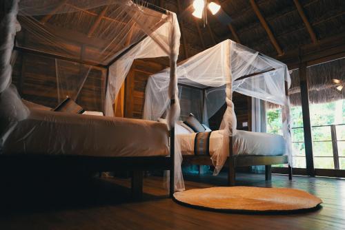 ein Schlafzimmer mit einem Himmelbett in einem Zimmer in der Unterkunft Bluebayou Bacalar in Bacalar
