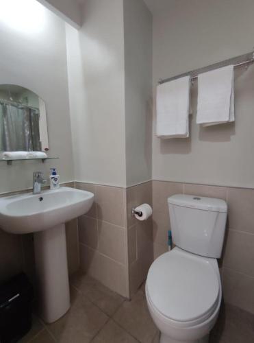 y baño con aseo blanco y lavamanos. en Simple and elegant 1 bed condo in Cebu city, en Cebú