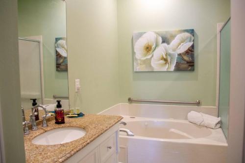 a bathroom with a sink and a bath tub at Quiet, Spacious Condo with 2 AWESOME pools and close to the beach in Gulfport