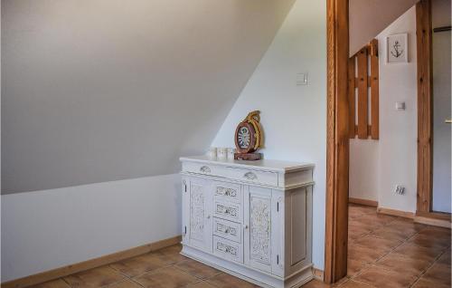 a white dresser in a room with a staircase at 1 Bedroom Amazing Apartment In Rydzewo in Rydzewo
