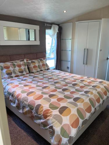 - une chambre avec un lit et une couette colorée dans l'établissement Meridian Lodge, à Great Billing