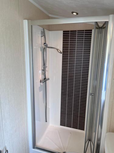 um chuveiro numa casa de banho com uma porta de vidro em Meridian Lodge em Great Billing