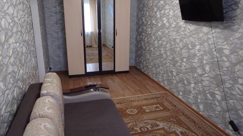 uma sala de estar com um sofá e um espelho em Конгресс em Petropavl
