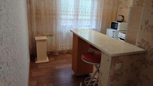 uma cozinha com um balcão e um bar com um banco em Конгресс em Petropavl