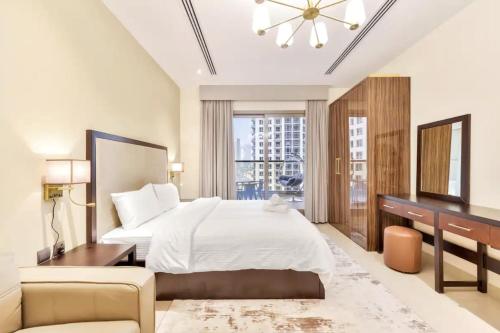 1 dormitorio con 1 cama grande, escritorio y silla en Residences at Elite Downtown Dubai en Dubái