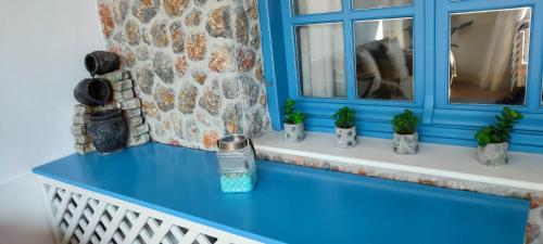 a blue counter with plants on a window sill at FILINA's luxury house in Maltezana
