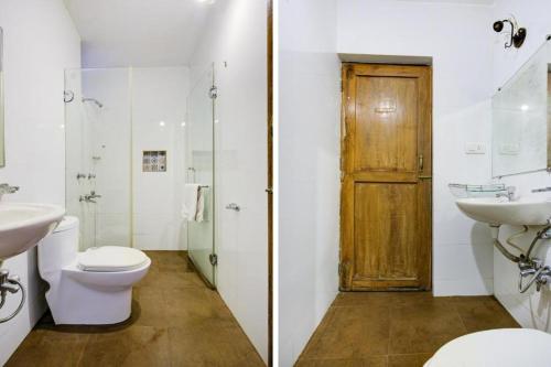 baño con aseo, lavabo y puerta en Sea Breeze Beach Resort Candolim, Goa, en Candolim