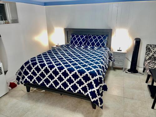 - une chambre avec une couette bleue et blanche sur un lit dans l'établissement LGA Airport near, Studio walk in bsmt Apt in a Private House!, à East Elmhurst