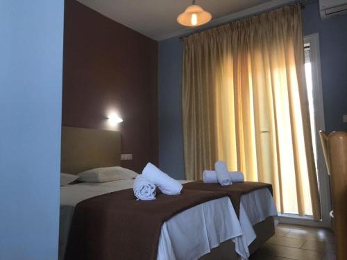 a hotel room with two beds with towels on them at Tasos Rooms in Prinos