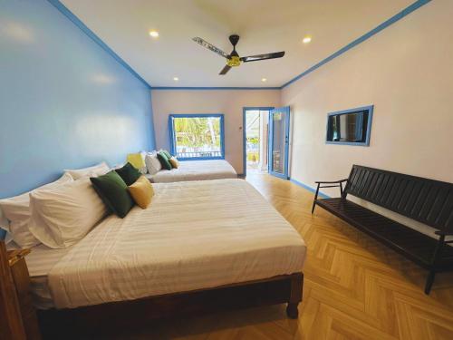 a bedroom with two beds and a ceiling fan at Sadakham Hotel in Luang Prabang